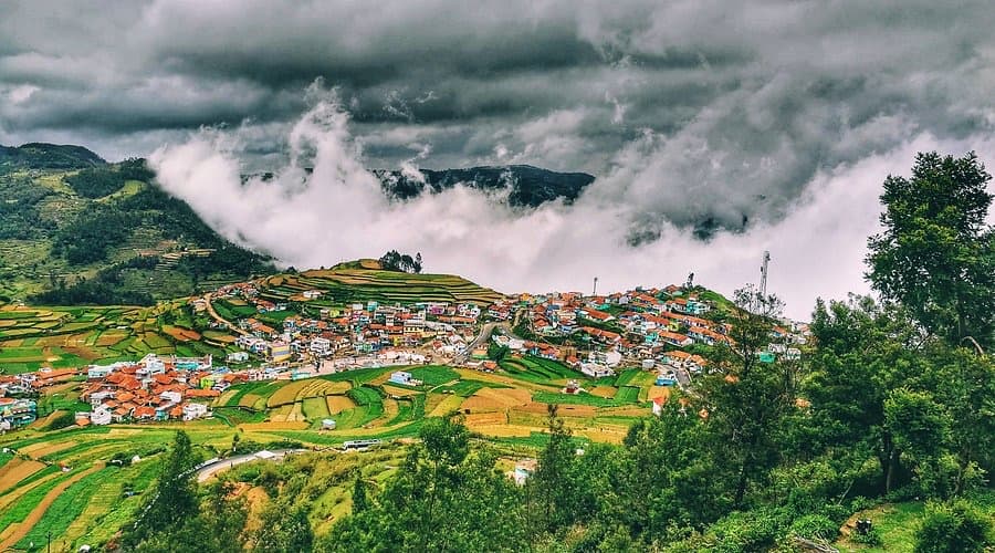 Misty hillside village with terraced fields near Kodaikanal
